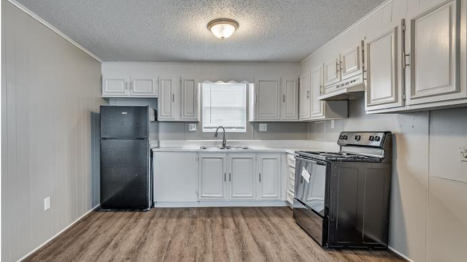 a kitchen with a stove, refrigerator and microwave at The Treehouse