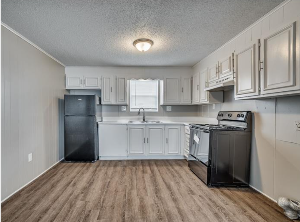 a kitchen with a stove, refrigerator and microwave at The Treehouse